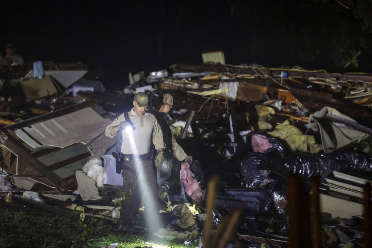Les soldats de l'Oklahoma State Highway Patrol recherchent les dégâts causés par la tempête, le mardi 7 mai 2024 à Barnsdall, Oklahoma. (Mike Simons/Tulsa World via AP)