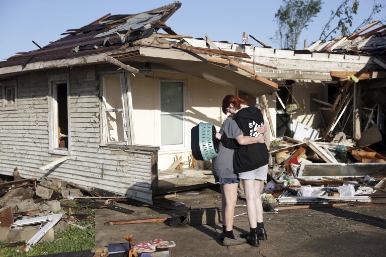 Joy King, à gauche, et sa petite-fille Crystal Maxey s'embrassent devant la maison de King qui a été détruite par une tornade le mardi 7 mai 2024 à Barnsdall, Okla. Les deux cherchaient les chats de King et récupéraient les objets qu'ils pouvaient.  (Mike Simons/Tulsa World via AP)